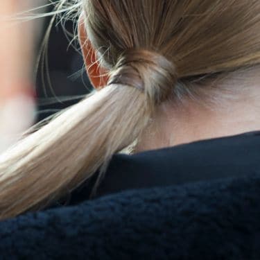 The back of a woman's head with a long blonde ponytail
